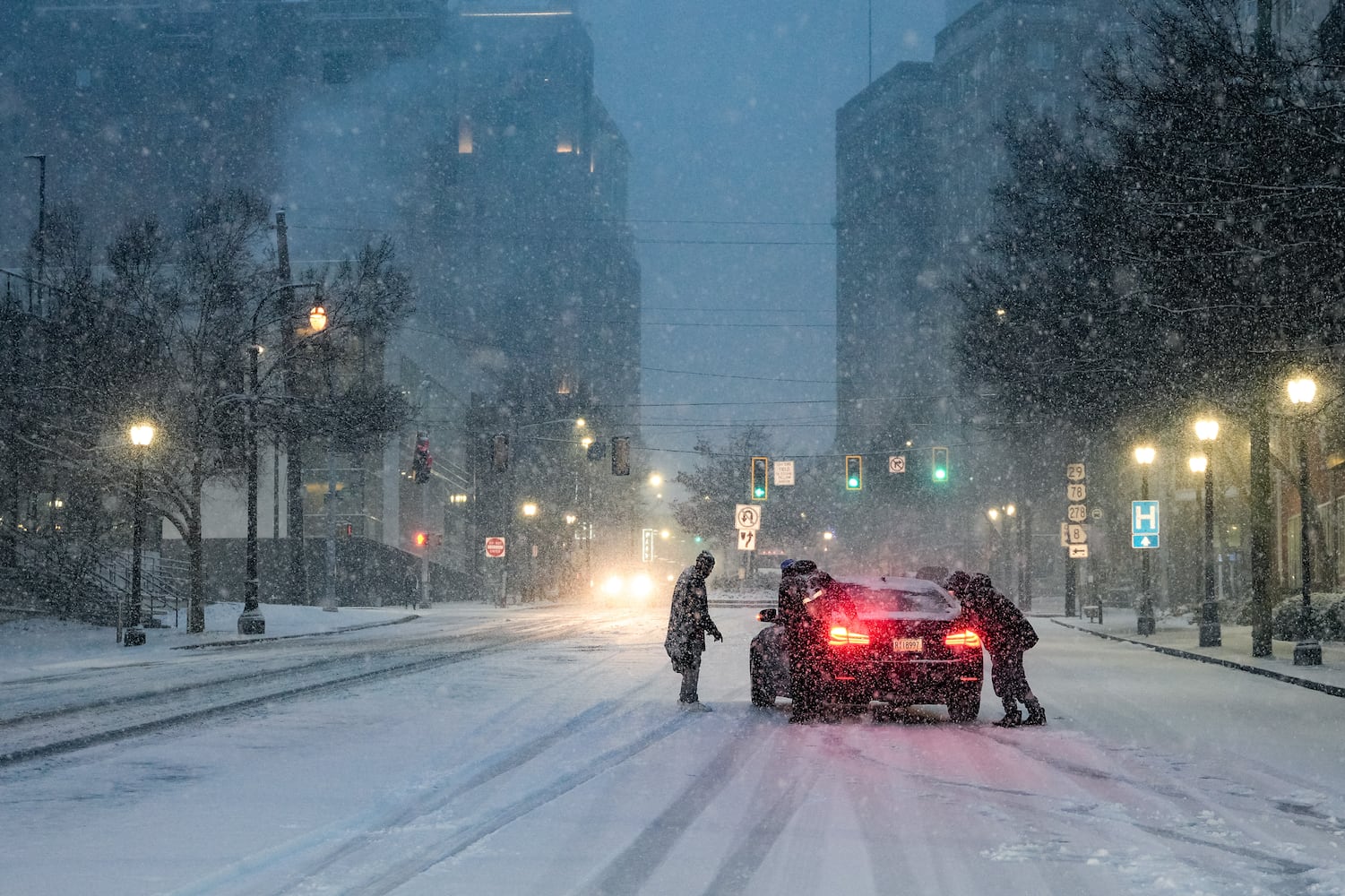 People attempt to help a stuck vehicle in downtown Atlanta, Georgia. Friday,  January 10, 2025 (Ben Hendren for the Atlanta Journal-Constitution)