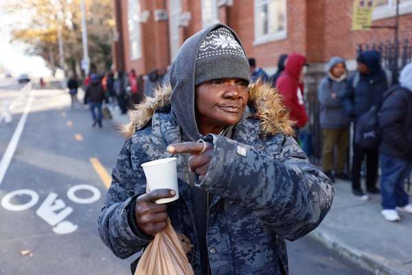  Angela Fairman, who has been homeless for four years, points to the alley where she sleeps, she feels very grateful after receiving a cup of coffee and a bag of sandwiches outside the Catholic Shrine of the Immaculate Conception on Thursday, Dec. 14, 2023.

Miguel Martinez /miguel.martinezjimenez@ajc.com