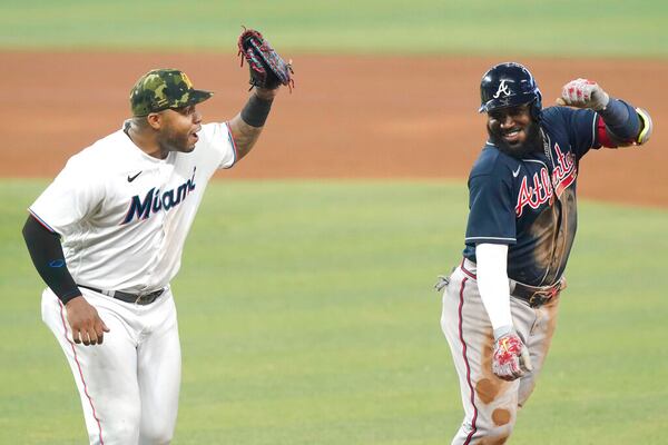 Marlins first baseman Jesus Aguilar (left) chases Braves left fielder Marcell Ozuna (20) during the eighth inning of a baseball game, Sunday, May 22, 2022, in Miami. (AP Photo/Marta Lavandier)