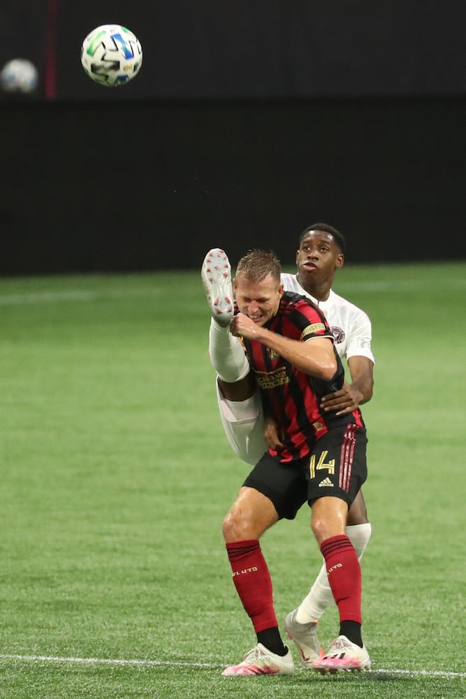 Atlanta United forward Adam Jahn (14) and Miami defender Andres Reyes (3) battle for a header in the first half at Mercedes-Benz Stadium Saturday, September 19, 2020 in Atlanta. JASON GETZ FOR THE ATLANTA JOURNAL-CONSTITUTION