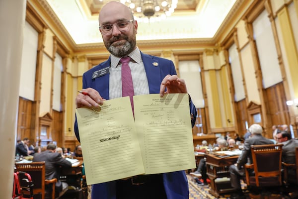 State Sen. Josh McLaurin, a Democrat from Sandy Springs, holds up his amendments to Senate Bill 291 after jokingly requesting to change "America First" to "Donald Trump First" on specialty license plates on Thursday at the Capitol in Atlanta.