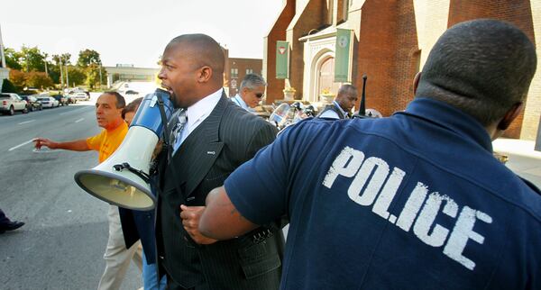 The Rev. Markel Hutchins (center) was arrested with other protesters on Nov. 10, 2010, in downtown Atlanta after they obstructed traffic during a protest in support of unauthorized immigrants. (John Spink/ jspink@ajc.com)