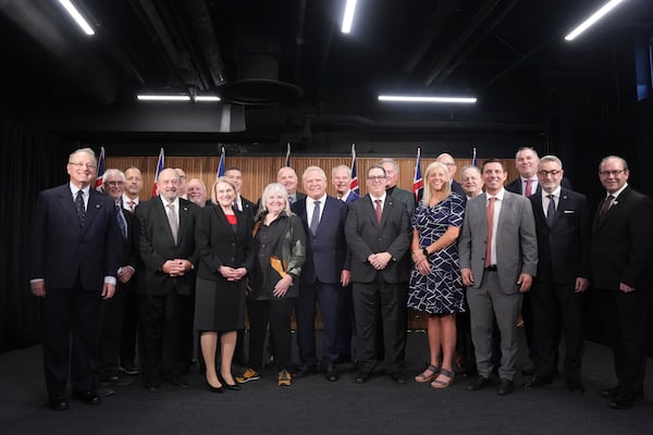 Ontario Premier Doug Ford, center, poses for a photo with mayors from selected municipalities and government ministers during a press conference in the Queen's Park Legislature in Toronto on Thursday Dec. 12, 2024. (Chris Young/The Canadian Press via AP)