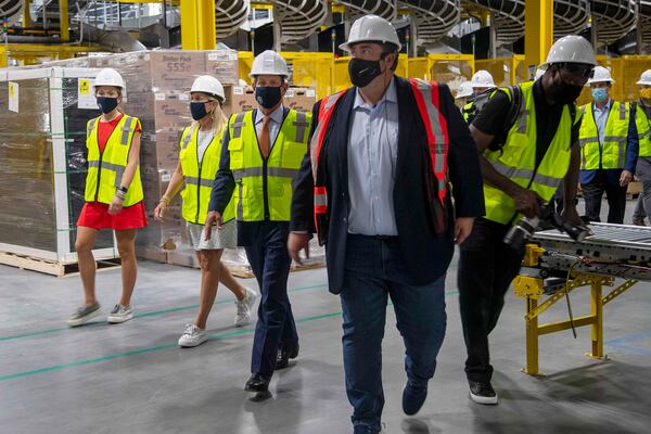 Gov. Brian Kemp (third from left), First Lady Marty Kemp (second from left) and their youngest daughter Amy Porter Kemp (left) are led on a tour by Amazon Region Director of Operations Robert Packett (second from right) at Amazon's ATL2 Fulfillment Center in Stone Mountain, Tuesday, September 1, 2020. (Alyssa Pointer / Alyssa.Pointer@ajc.com)