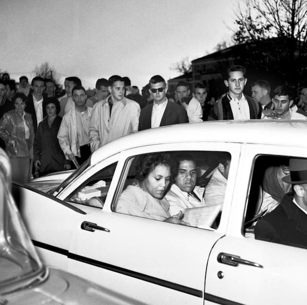 University of Georgia students shout and jeer at Charlayne Hunter (left), 18, and Hamilton Holmes, 19, as they leave the administration building after completing registration in January 1961. Admitted under federal court order, they were the first Black students to attend the university in its history. (1961 AP photo)