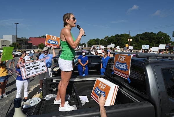 Amy Henry leads parents, students and community members during a rally to call on Superintendent Chris Ragsdale and the Cobb school board to offer in-person classes alongside virtual learning outside Cobb County Civic Center in Marietta on Saturday, August 1, 2020. (Photo: Hyosub Shin / Hyosub.Shin@ajc.com)