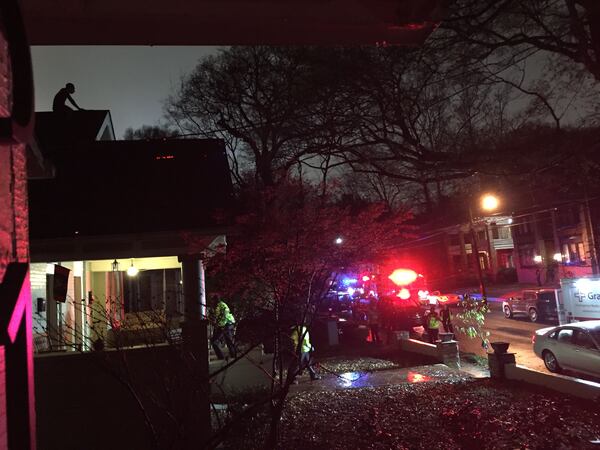 A man was on the roof of this home in the 300 block of 4th Street since 5:15 a.m. Friday. SUZANNE VAN ATTEN / SUZANNE.VANATTEN@AJC.COM