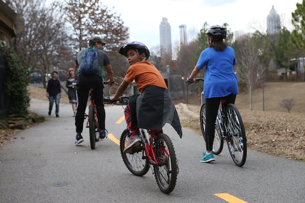 Benjamin Blackburn, 8, looks back as his father, Ben Blackburn, 45, and sister Lindsay Blackburn, 15, ride off on the Beltline loop in Atlanta. They're in the heart of the 5th Congressional District, an area Donald Trump in 2016 described as in "horrible shape and falling apart" while venting at that time against U.S. Rep. John Lewis. (HENRY TAYLOR / HENRY.TAYLOR@AJC.COM)