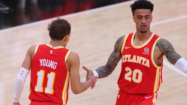 Hawks forward John Collins is congratulated by teammate Trae Young after scoring against the Philadelphia 76ers on a pass from Young in Game 3 of the Eastern Conference semifinals series Friday, June 11, 2021, at State Farm Arena in Atlanta. (Curtis Compton / Curtis.Compton@ajc.com)