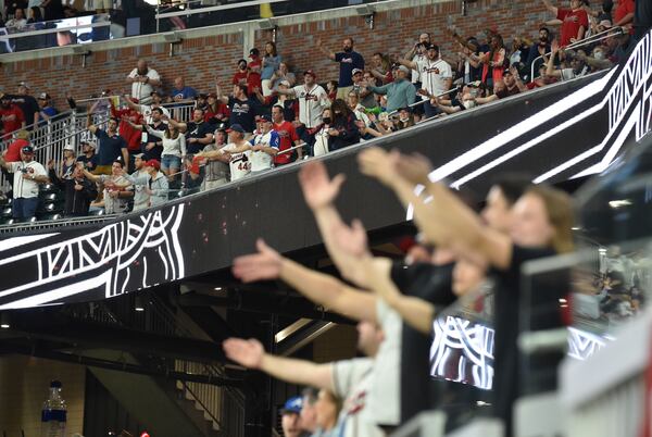 Braves fans perform the "Tomahawk Chop" during Atlanta Braves home opener Friday, April 9, 2021,at Truist Park in Atlanta.  (Hyosub Shin / Hyosub.Shin@ajc.com)