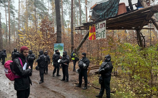 Police officers break up a protest camp housing environmental activists at the Tesla protest camp in the forest near the car factory in Grünheide, Germany, Tuesday Nov. 19, 2024. (Lutz Deckwerth/dpa via AP)