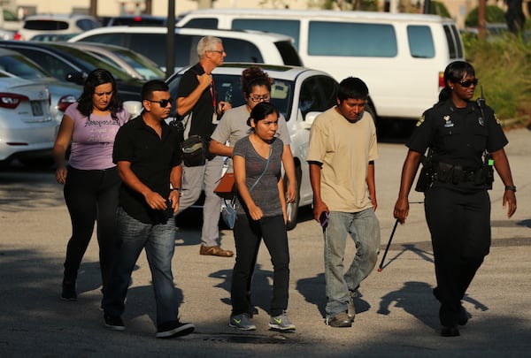 Family members are escorted into a community center where law enforcement officers are offering answers and support. AJC photo: Curtis Compton