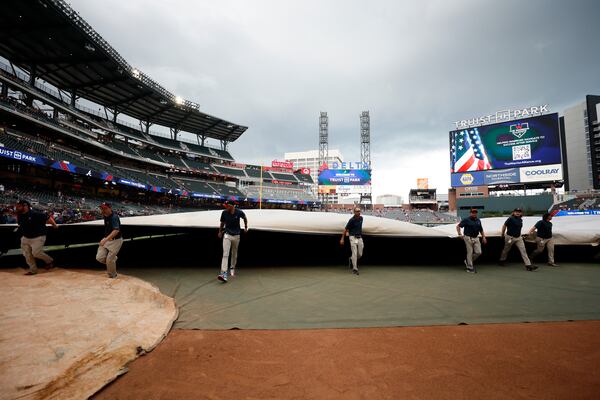 Ground crew workers cover the field as rain approaches the area at Truist Park moments before the game between the Atlanta Braves and Cincinnati Reds at Truist Park on Tuesday, July 23, 2024, in Atlanta.
(Miguel Martinez/ AJC)