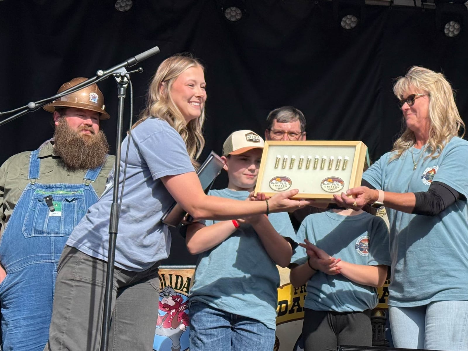 Brianna Ray Weaver (left) receives 10 ounces of framed gold from her mother, Tammy Ray, on Saturday from their family's mine, Crisson Gold Mine. The gold is to be utilized in the regilding of the Atlanta Capitol dome. Courtesy of Patrick Quirk.