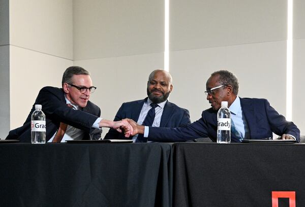 Officials from Grady, Fulton and DeKalb Counties (from left) John Haupert, president and CEO of Grady Health System, Jevon Gibson, CEO of The Fulton-DeKalb Hospital Authority, and Mike Thurmond, CEO of DeKalb County, celebrate after signing documents during a press conference to announce and sign a new deal to subsidize the hospital for indigent medical care at Grady Memorial Hospital, Tuesday, December 9, 2024, in Atlanta. (Hyosub Shin / Hyosub.Shin@ajc.com)