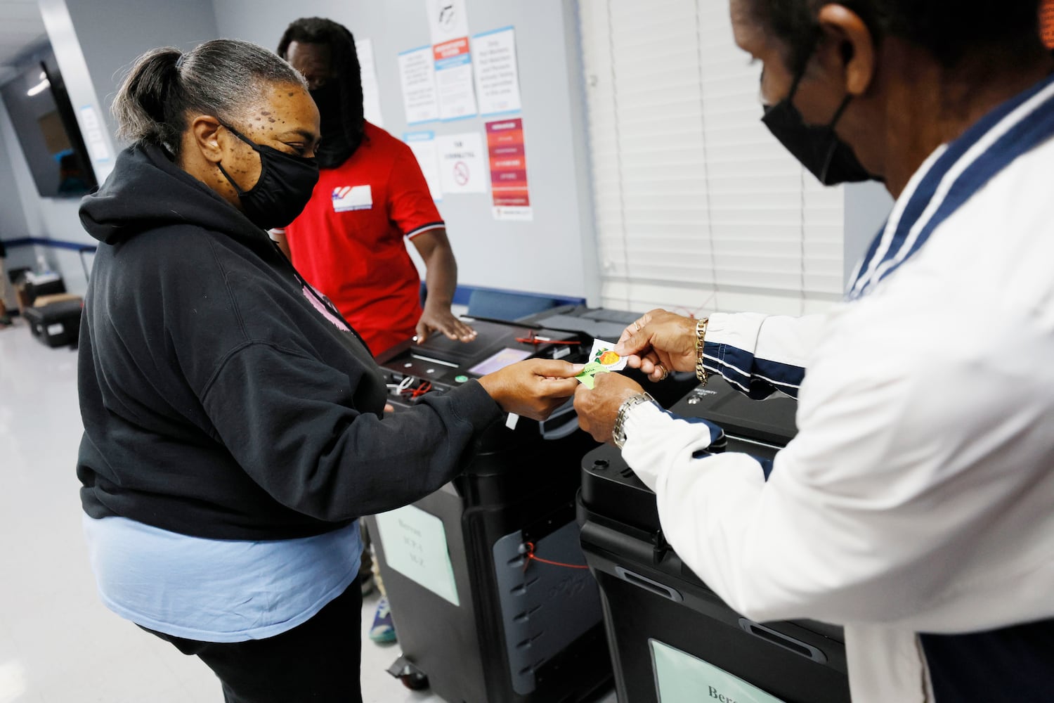 Connie Chandler from Stone Mountain exchanged her ballot card with a pool worker for a Georgia voter sticker during the first day of early voting of the general elections on Monday, October 17, 2022.Miguel Martinez / miguel.martinezjimenez@ajc.com