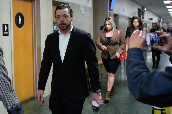 Tim Oliver Lee, left, brother of Cash App founder Bob Lee, and other family members walk to Department 28 to enter the courtroom at the Hall of Justice for the murder trial of Nima Momeni, Monday, Dec. 2, 2024, in San Francisco. (AP Photo/Godofredo A. Vásquez)