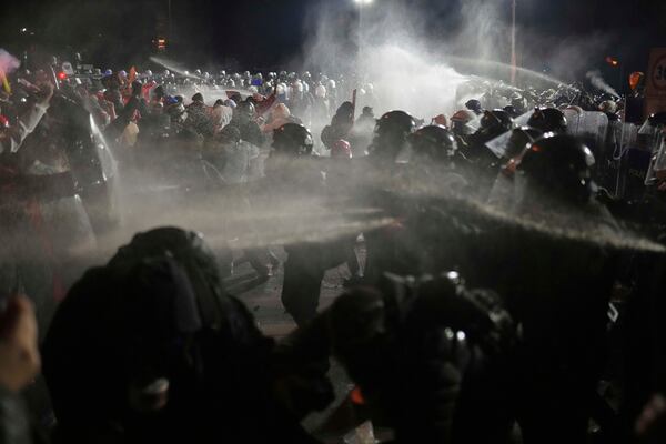 Riot police officers clash with protesters during a protest after Istanbul's Mayor Ekrem Imamoglu was arrested and sent to prison, in Istanbul, Turkey, Sunday, March 23, 2025. (AP Photo/Francisco Seco)