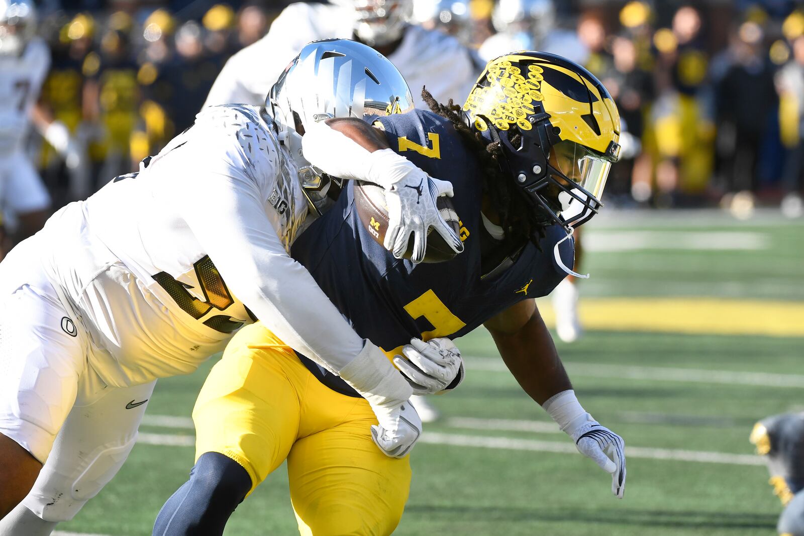 Michigan running back Donovan Edwards, right, is tackled by Oregon defensive lineman Derrick Harmon in the first half of an NCAA college football game, Saturday, Nov. 2, 2024, in Ann Arbor, Mich. (AP Photo/Jose Juarez)