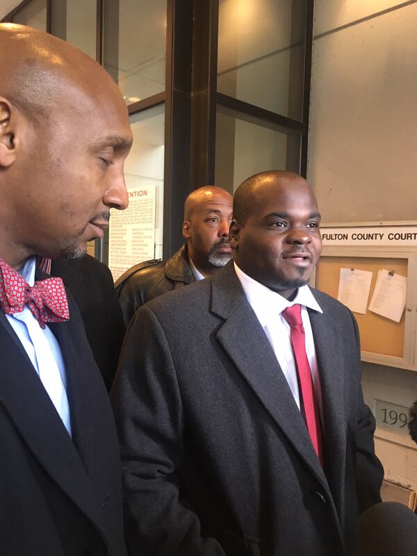 Basil Eleby, surrounded by his attorneys, address reporters after a Friday, December 8, 2017 court appearance.