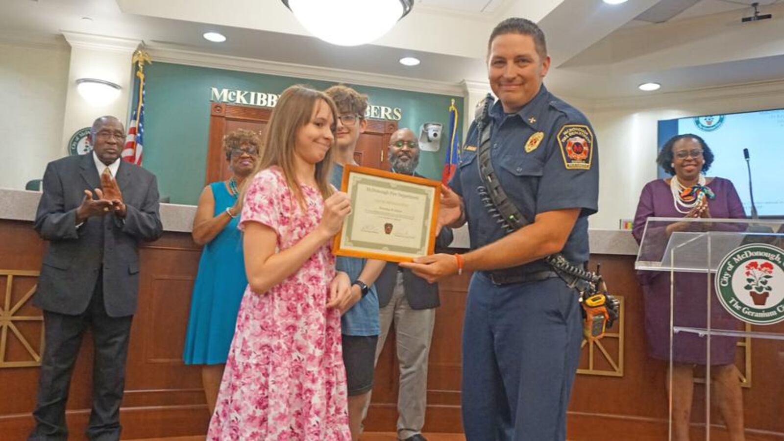 McDonough Fire Department Battalion Chief Barry Jenkins presents Brantley Abbott with a Valor Award. (Courtesy of City of McDonough)