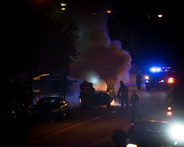  Firefighters work to douse the police car Monday night. Photo: special to the AJC