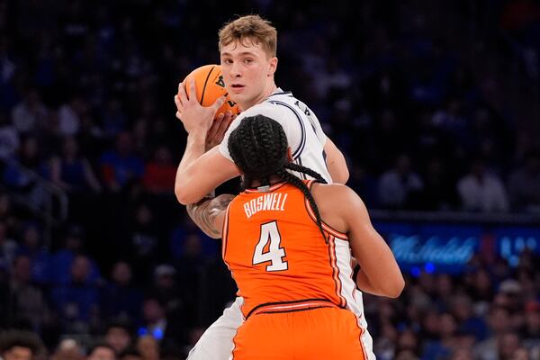 Duke's Cooper Flagg (2) protects the ball from Illinois' Kylan Boswell (4) during the first half of an NCAA college basketball game Saturday, Feb. 22, 2025, in New York. (AP Photo/Frank Franklin II)