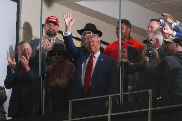 Former President Donald Trump waves to the crowd attending the football game between Alabama and Georgia in Tuscaloosa on Saturday.