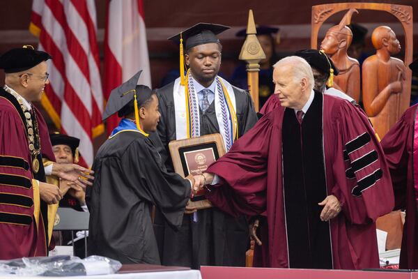 President Joe Biden shakes hands with salutatorian Dwayne Allen Terrell II (left) at the commencement ceremony at Morehouse College in Atlanta on Sunday, May 19, 2024. (Arvin Temkar / AJC)