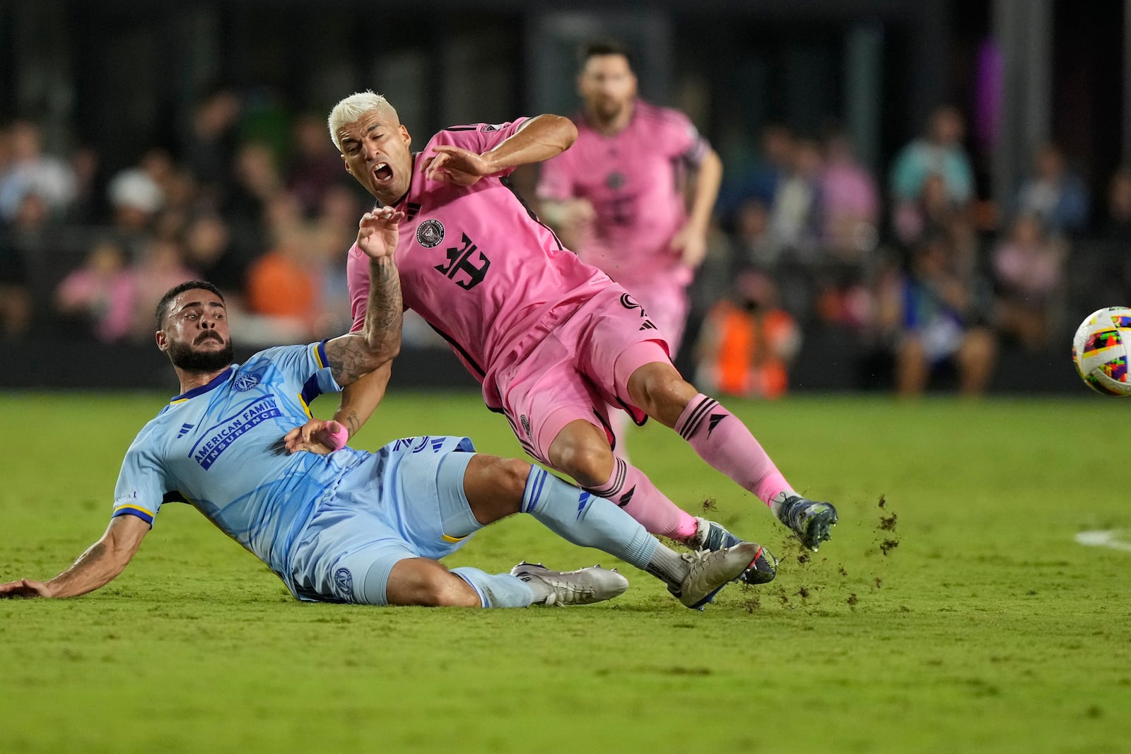 Atlanta United defender Derrick Williams (3) and Inter Miami forward Luis Su·rez (9) fall after kicking the ball during the first half of match one of their MLS playoff opening round soccer match, Friday, Oct. 25, 2024, in Fort Lauderdale, Fla. (AP Photo/Lynne Sladky)