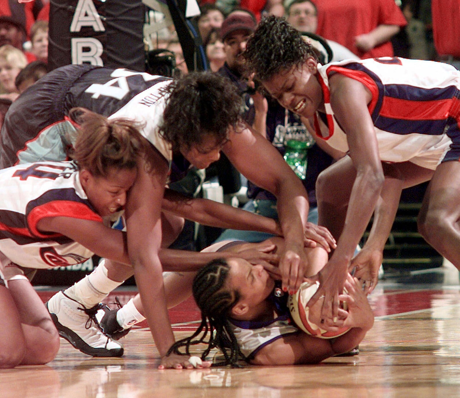 FILE - New York Liberty's Teresa Weatherspoon, bottom, and Kym Hampton battle against Houston Comets Cynthia Cooper and Sheryl Swoopes for a loose ball during the first half in Game 3 of the WNBA Finals, Sept. 5, 1999, in Houston. (AP Photo/David J. Phillip, File)