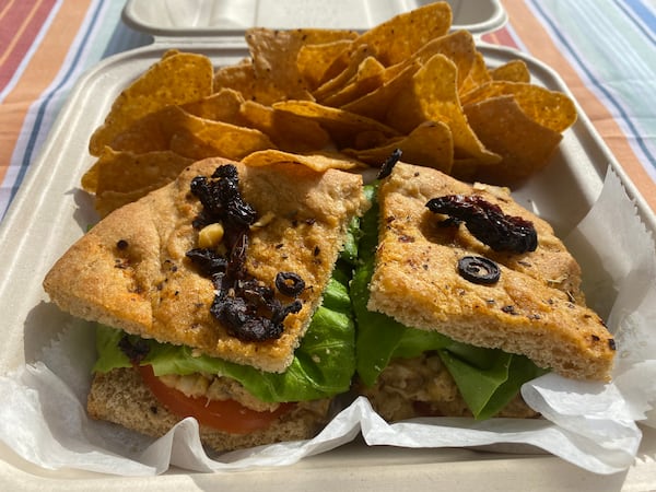 Garnet Gal's offers a variety of sandwiches, including vegan options like the Chickpea Sunflower Seed, served on your choice of bread (pictured  is sun-dried tomato foccacia) with a side of sweet potato chips. 
Ligaya Figueras / ligaya.figueras@ajc.com