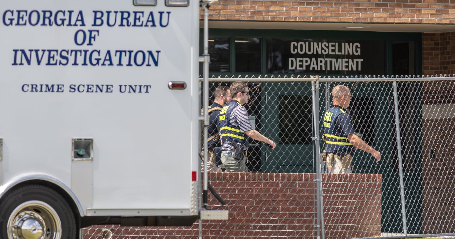 The GBI work behind the now fenced-in school for their investigation. Students and well wishers arrived with flowers to place at the flag pole at Apalachee High School in Winder on Thursday, Sept. 5, 2024. A 14-year-old is accused of shooting and killing two fellow students and two teachers and injuring nine others at Apalachee High School on Wednesday. (John Spink/AJC)