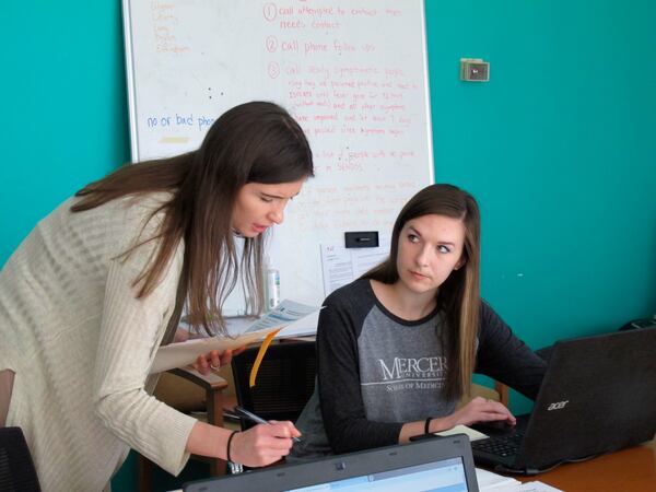 In this April 22, 2020, file photo, medical student Catherine Waldron talks with epidemiologist Elizabeth Goff at the Georgia Department of Public Health's district office in Savannah, Ga. Waldron is among about 30 medical students helping the Georgia health agency's coastal district with contact tracing aimed at identifying relatives, friends and co-workers of people infected by the virus to prevent its spread to others. (AP Photo/Russ Bynum, File)