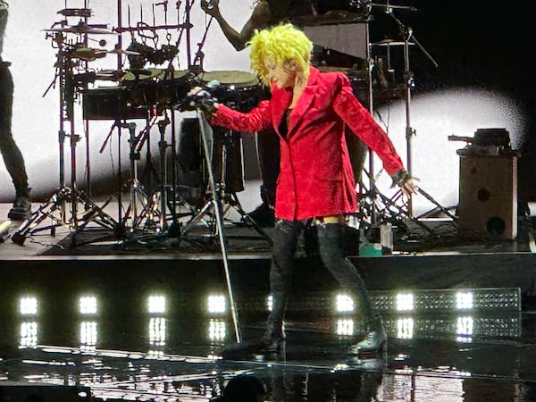 Cyndi Lauper gives her signature pose she did on the cover of her "She's So Unusual" breakthrough album from 1983 during her State Farm Arena concert on Nov. 10, 2024. RODNEY HO/rho@ajc.com