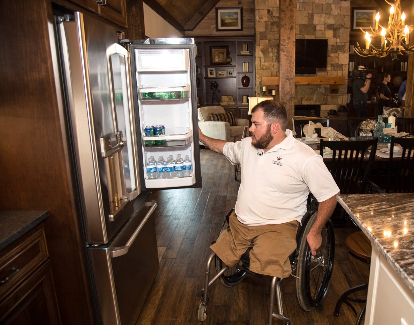 Retired Cpl. Sean Adams checks out the refrigerator at his new specially adapted smart home in Maysville on May 19, 2017. Much of the living space is simply designed so that he can move about easily in his wheelchair. STEVE SCHAEFER / SPECIAL TO THE AJC