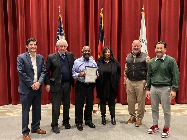 For 10 years, Johnson (center) served on the Sandy Springs Board of Appeals — which decides on requests for variances from city zoning regulations — before resigning last December with a city proclamation issued in his honor.  He is pictured with fellow members of the Board of Appeals and holding a city proclamation issued in his honor. Photo courtesy Sandy Springs