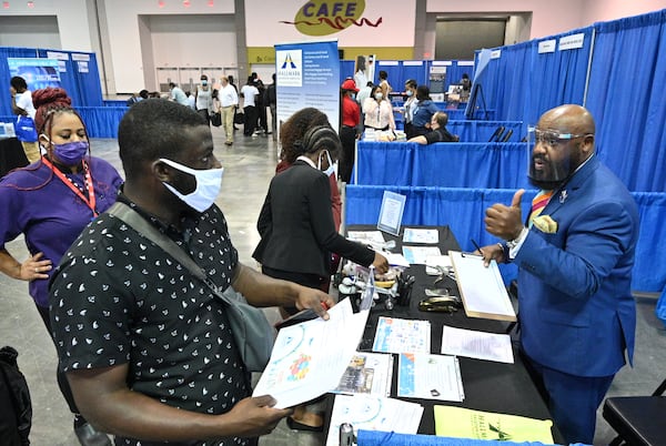 Timothy Hosea (right), regional manager with Hallmark Aviation Services, meets with job seekers at ATL Airport Career Fair at Georgia International Convention Center on Wednesday. (Hyosub Shin / Hyosub.Shin@ajc.com)