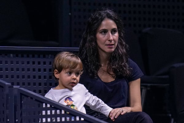 Rafael Nadal's wife, Xisca Perello, and their son, Rafael Nadal Jr watch the training session of Rafael Nadal at the Martin Carpena Sports Hall, in Malaga, southern Spain, on Saturday, Nov. 16, 2024. (AP Photo/Manu Fernandez)