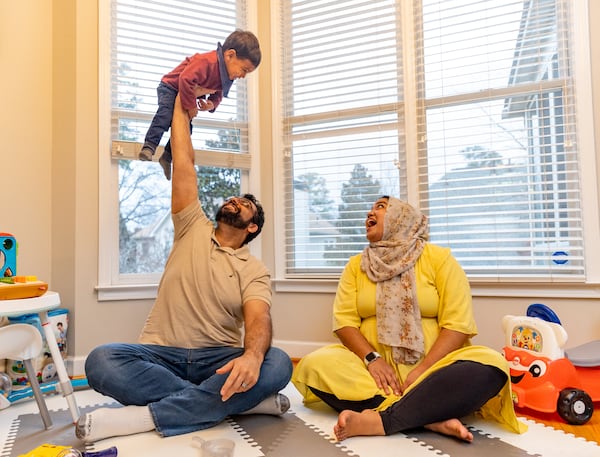 The Covid pandemic has changed priorities for the Arif family — Shahrukh Arif, left, Safia, and their 18-month-old son Umar. Safia was a high school English teacher at a private Muslim school at the beginning of the pandemic and now works from home selling merchant services to restaurants while raising Umar with her husband. Shahrukh has a hybrid schedule with his work, which has allowed him to spend more time with his family. (Jenni Girtman for The Atlanta Journal-Constitution)