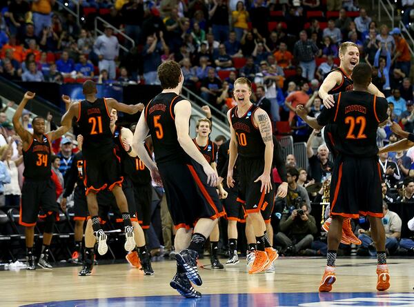 Bud Thomas (5) , Ike Nwamu (10), and Darious Moten (22) of the Mercer Bears celebrate after defeating the Duke Blue Devils 78-71 in the 2014 NCAA Basketball Tournament at PNC Arena March 21, 2014 in Raleigh, N.C.