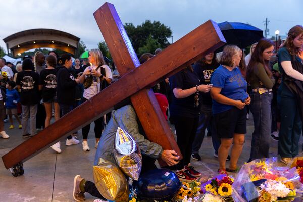 Dan Beazley carries a cross at a vigil at Jug Tavern Park in Winder on Sept. 6 days after a 14-year-old Apalachee High School student is accused of killing four people. (Arvin Temkar / AJC)