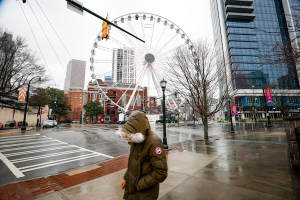 A person walks on Centennial Olympic Drive across from the Ferris wheel in downtown Atlanta on Wednesday.
(Miguel Martinez/ AJC