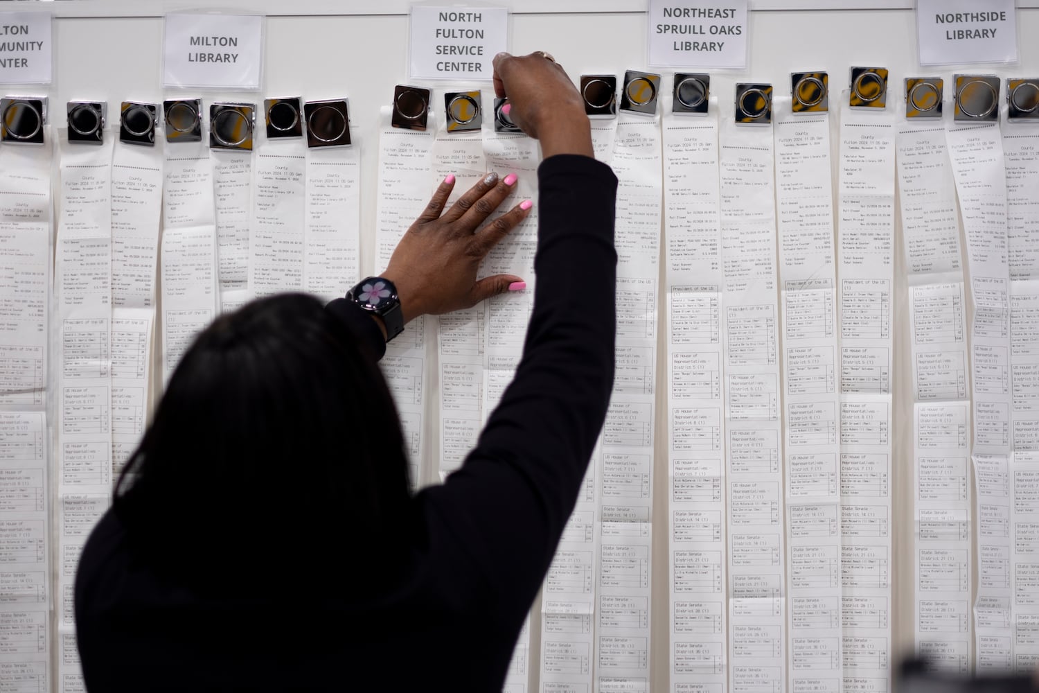 A worker unfurls the advance voting tabulations at the Fulton County election hub in Fairburn on Tuesday, Nov. 5, 2024. Ben Gray for the Atlanta Journal-Constitution