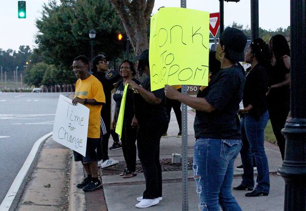 People gather outside of the Buford City Schools football stadium to protest Buford School District Superintendent Geye Hamby at their game against Jonesboro High School. Jenna Eason / Jenna.Eason@coxinc.com