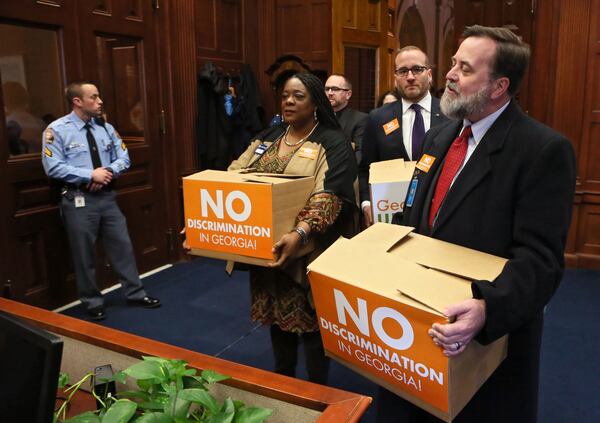 Jeff Graham, right, executive director of Georgia Equality, leads supporters carrying boxes of postcards into then-Gov. Nathan Deal’s office on March 2, 2016. Representatives from gay rights groups delivered copies of 75,000 emails to state leaders urging them to defeat religious liberty legislation they believed would legalize discrimination. (Bob Andres/ AJC)