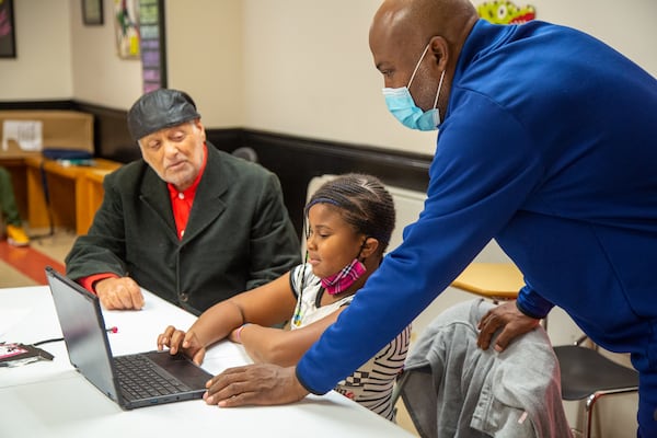 (left to right) Rick McDevitt watches as eight-year-old Maddison Brown gets help doing her homework from program & facilities manager, George Epps at The Rick McDevitt Youth Center. PHIL SKINNER FOR THE ATLANTA JOURNAL-CONSTITUTION.