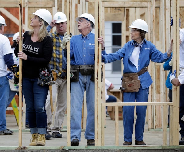 Former President Jimmy Carter works between his wife, Rosalynn Carter, right, and singer Trisha Yearwood, left, at a Habitat for Humanity building site Monday, Nov. 2, 2015, in Memphis, Tenn. Behind Yearwood is her husband, singer Garth Brooks. Carter and his wife, Rosalynn, have volunteered a week of their time annually to Habitat for Humanity since 1984, events dubbed "Carter work projects" that draw thousands of volunteers and take months of planning. (AP Photo/Mark Humphrey)