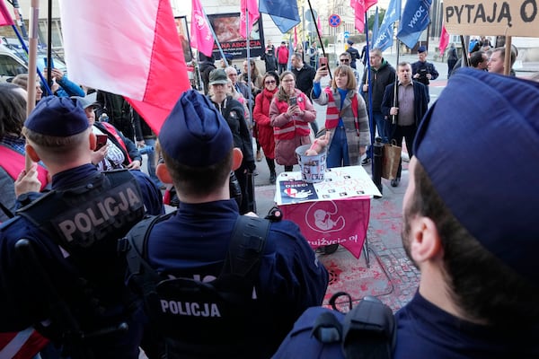 Protesters stand outside the newly opened center where women can go to have abortions with pills, during its inauguration, in Warsaw, Saturday March 8, 2025. (AP Photo/Czarek Sokolowski)