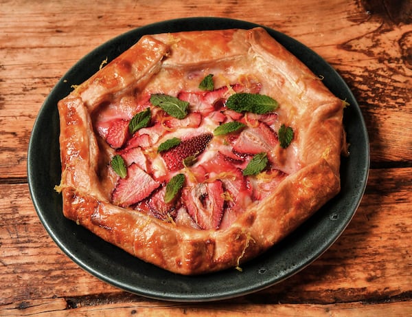 For this sweet galette by Two Urban Licks executive chef Shain Wancio, strawberries are placed on top of sweetened cream cheese on a piece of pie crust. (Styling by chef Shain Wancio / Chris Hunt for the AJC)